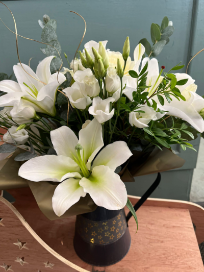 Twinkle Twinkle - A handtied bouquet displayed in a Navy jug, flowers in shades of white matched with seasonal foliage.